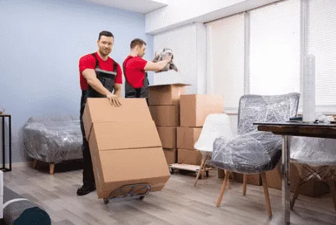 Movers carrying cartons on a trolley in a home
